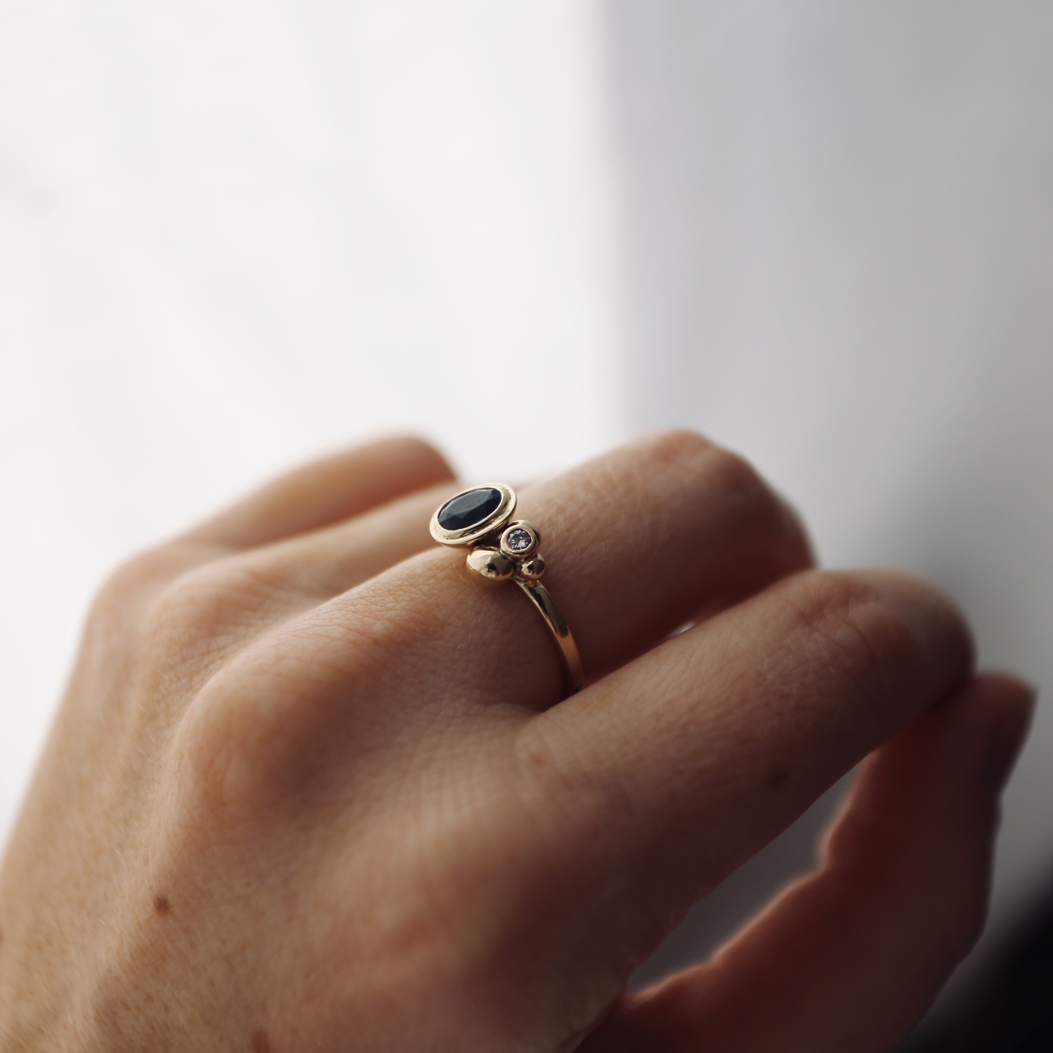 Cup set sapphire with gold clusters and diamond on a gold shank